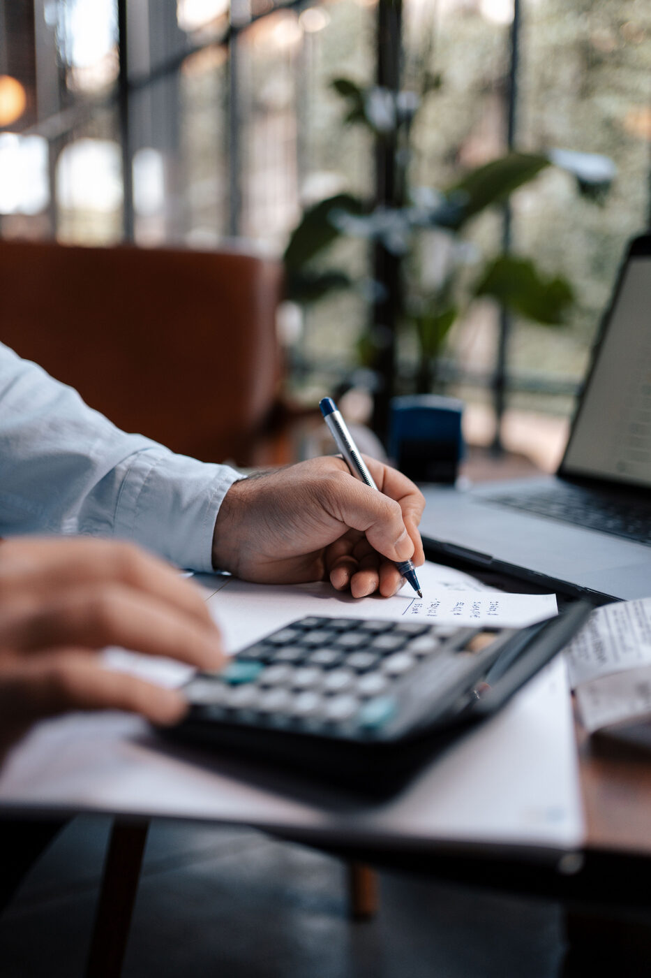 Investisseur calculant la rentabilité locative d'un bien immobilier avec calculatrice et notes — étude patrimoniale Bercail
